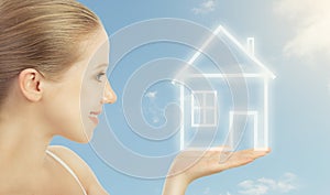 Concept housing. woman holding a house