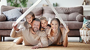 Concept housing  young family. mother father and children under fake roof in  new home