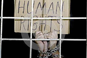 Concept human rights freedom of speech hands shackled with an iron chain hold a cardboard sign with the inscription human rights