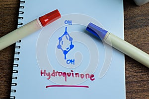 Concept of Hydroquinone molecule write on book isolated on Wooden Table. Structural chemical formula