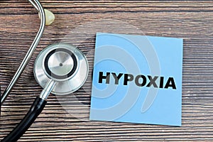 Concept of Hypoxia write on sticky notes with stethoscope isolated on Wooden Table