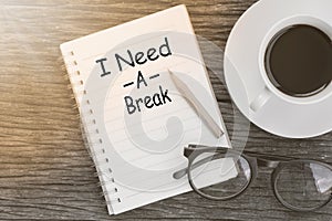 Concept I need a break message on notebook with glasses, pencil