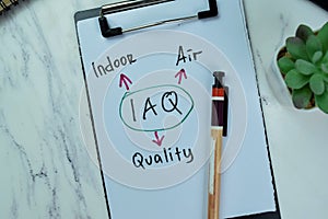 Concept of IAQ - Indoor Air Quality write on paperwork with statistics isolated on Wooden Table photo