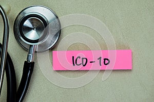Concept of ICD-10 write on sticky notes with stethoscope isolated on Wooden Table