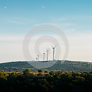 Concept idea eco power energy. wind turbine on hill with sunset