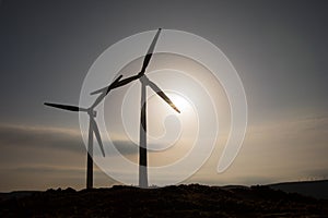 Concept idea eco power energy. wind turbine on hill with sunset. Wind Turbine producing alternative energy