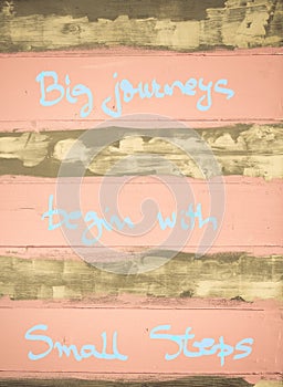 Concept image of Big Journeys begin with small steps motivational quote