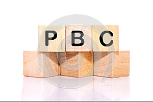 Concept image of Business Acronym PBC as Performance Based Contract written on wooden cubes on a white background