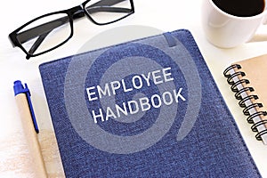 Concept image of employee handbook over wooden office table. top view