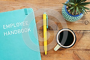 Concept image of employee handbook over wooden office table. top view