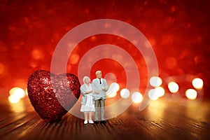 Concept image of Happy elderly couple hugging. valentines day idea over red glitter background