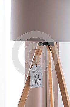 Concept image with the text Do What You Love hanged on a wooden plate under a lamp