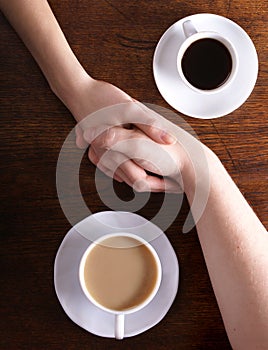 Imagen conceptual de dos manos a café 