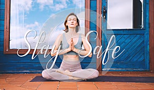 Concept image of woman doing yoga or meditation with text Stay Safe