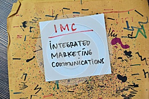 Concept of IMC - Integrated Marketing Communications write on sticky notes isolated on Wooden Table