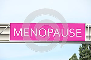 Concept of impending climacteric. Pink sign with word MENOPAUSE outdoors