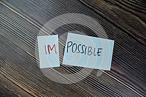 Concept of Impossible to be possible write on sticky notes isolated on Wooden Table