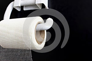 The concept of inadequate savings. Mesh fiber hangs on toilet paper holder on black background. Irrational thinking as Plan B or photo