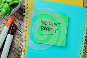 Concept of Incident Report write on sticky notes isolated on Wooden Table