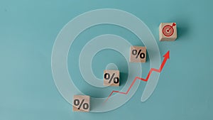 Concept of increasing sales. Wooden cubes with percentage icon and Rising arrow red on blue background.