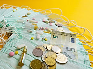 The concept of inflation in medicine. Medical masks, medicines and money on a yellow background.