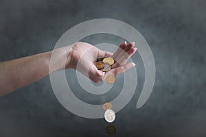 Concept of inflation. Woman hand hold an euro coins. Euro coins falling from woman hand. Declining value of money - Inflation