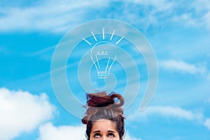 Concept of innovation, idea, creativity. a girl looking up at a drawn light bulb