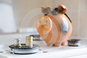 the concept of insurance or budget savings . two columns of coins on the gas burner on the background of the piggy Bank