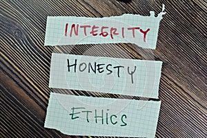 Concept of Integrity, Honesty and Ethics write on sticky notes isolated on Wooden Table