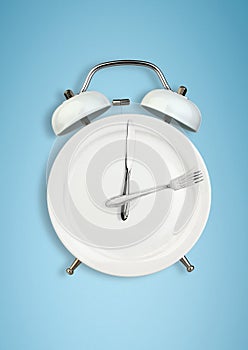 Concept of intermittent fasting, lunchtime, diet and weight loss. Plate as Alarm clock