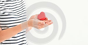 Concept International Day of Families or World heart day. Heart in the hands of young woman on a white background. I love you.