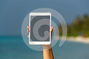 Concept of internet and communication. blank empty tablet computer in the hands of women on the beach