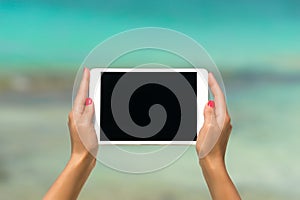 Concept of internet and communication. blank empty tablet computer in the hands of women on the beach