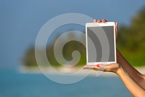 Concept of internet and communication. blank empty tablet computer in the hands of women on the beach