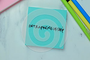 Concept of Intrapreneurship write on sticky notes isolated on Wooden Table photo