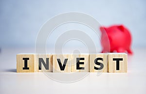 concept of invest word on wooden ubes