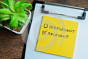 Concept of Irrelevant or Relevant write on sticky notes isolated on Wooden Table