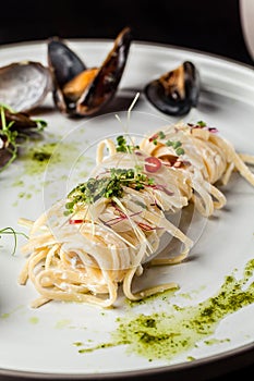 The concept of Italian cuisine. Pasta with cream sauce, pesto and seafood, mussels. European cuisine. Serving dishes