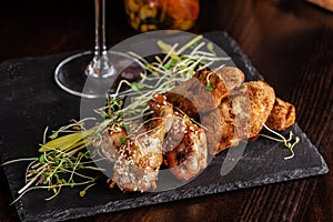 The concept of Italian cuisine. Snack to beer. Glazed chicken legs and chicken wings, breaded. Serving dishes in the restaurant