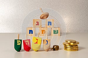 Concept of of jewish religious holiday hanukkah with wooden spinning top toys dreidel, cubes sayin