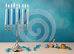 concept of jewish religious holiday hanukkah with wooden spinning top toys & x28;dreidel& x29;, traditional chandelier menorah and