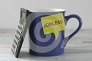 Concept of jobless with calculator lean on a blue mug. Unemployment issue rises due to pandemic virus of covid-19