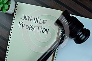 Concept of Juvenile Probation write on a book with gavel isolated on Wooden Table photo