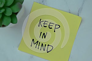 Concept of Keep in Mind write on sticky notes isolated on Wooden Table