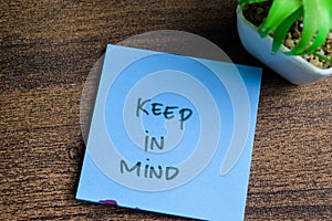 Concept of Keep in Mind write on sticky notes isolated on Wooden Table