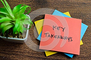 Concept of Key Takeaways write on sticky notes isolated on Wooden Table