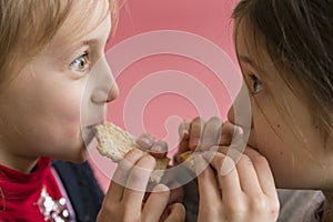 concept kids fighting for food. girls bite one slice of bread. Food shortage concept