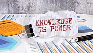 Concept:Knowledge is power written on torn paper with black background and pen