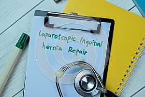 Concept of Laparoscopic Inguinal Hernia Repair write on paperwork with stethoscope isolated on Wooden Table