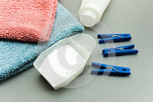 Concept of laundry process. White plastic packaging of laundry detergent, liquid powder, washing conditioner, towels and